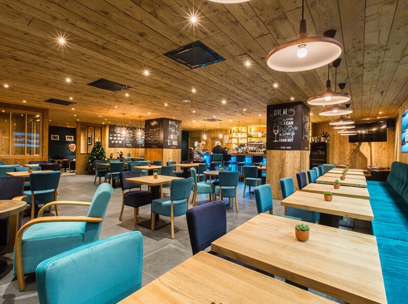 Installation électrique d’un bar-restaurant à Morzine avec éclairage encastré au plafond en bois et suspensions cuivrées