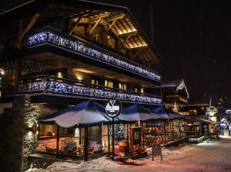 Chalet de nuit à Morzine décoré de guirlandes lumineuses blanches sur les balcons, réalisation électrique par Bernard Braize Électricité