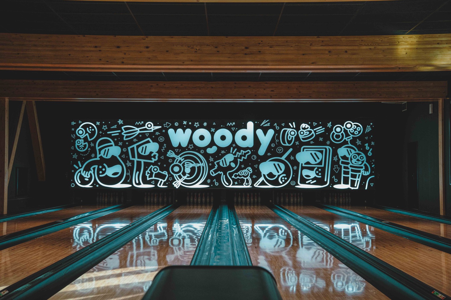 Installation électrique d’un panneau lumineux Woody au fond d’une piste de bowling, réalisée par Bernard Braize Électricité à Morzine