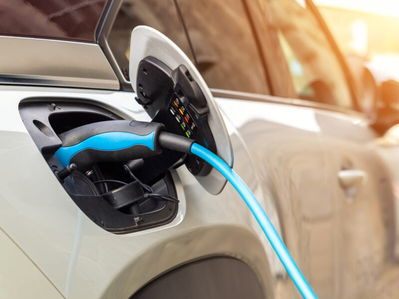 Voiture électrique branchée à une borne de recharge en ville