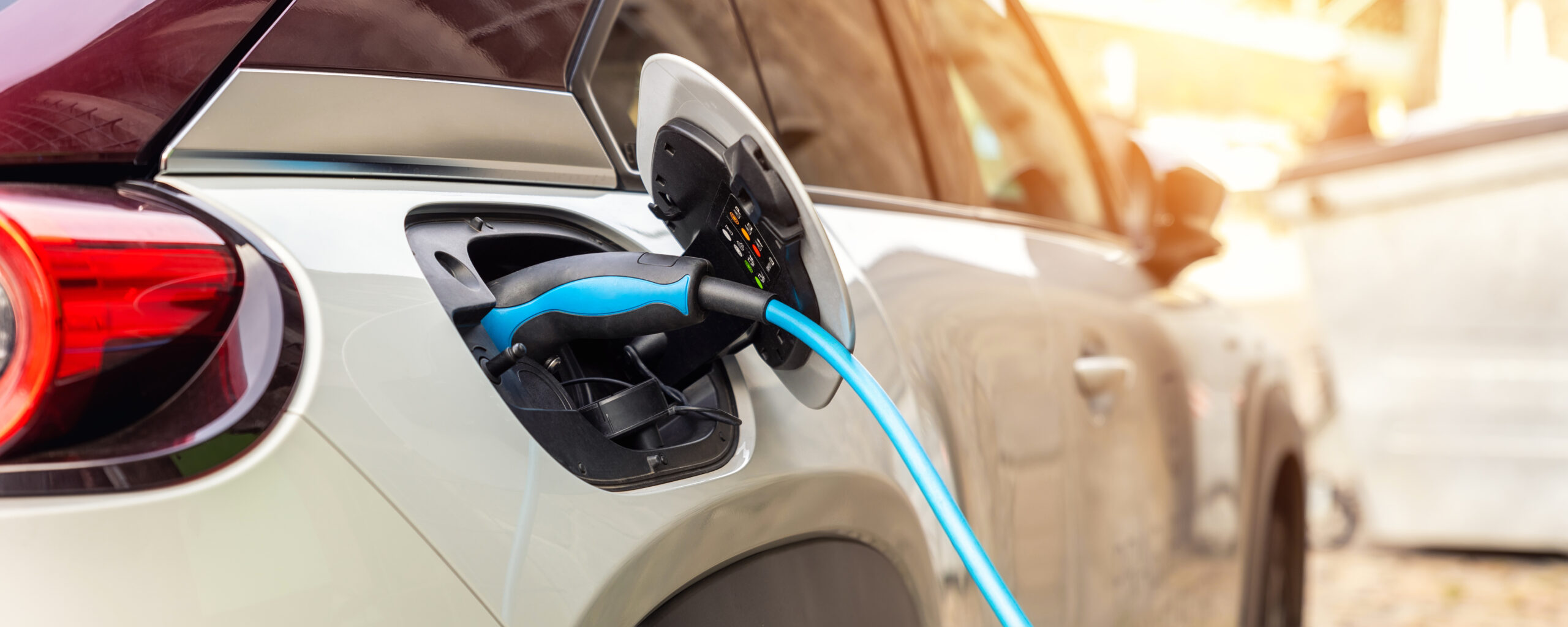 Voiture électrique branchée à une borne de recharge en ville